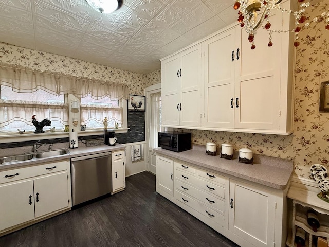 kitchen featuring a sink, black microwave, white cabinetry, stainless steel dishwasher, and dark wood finished floors