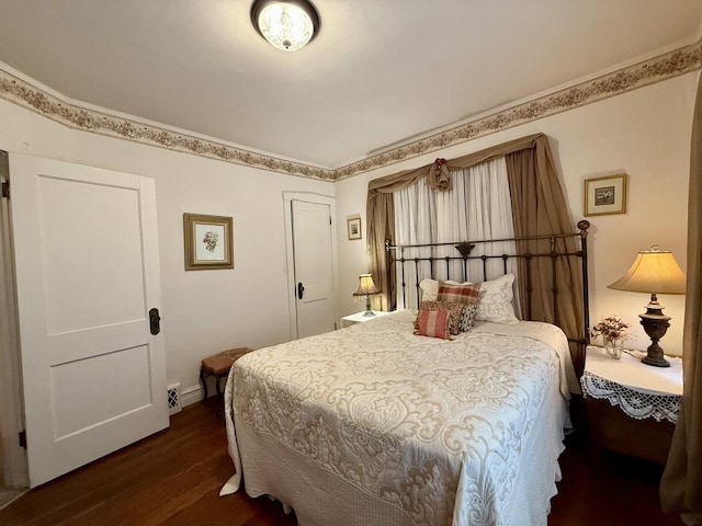 bedroom with dark wood finished floors and baseboards