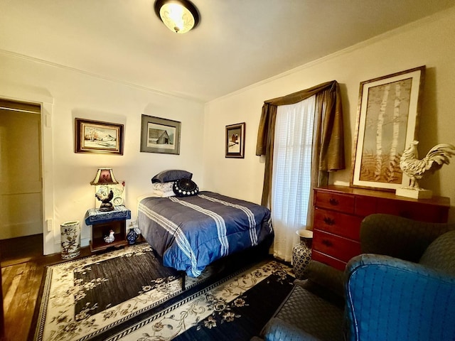 bedroom featuring wood finished floors and crown molding