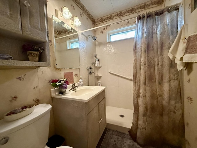 full bathroom featuring a stall shower, toilet, and vanity