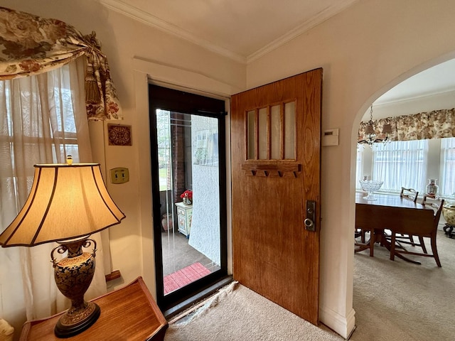 entryway with arched walkways, carpet floors, and plenty of natural light