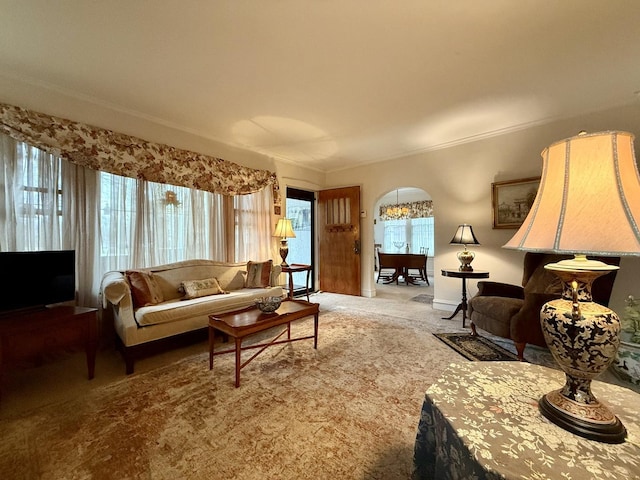 carpeted living area featuring arched walkways and crown molding