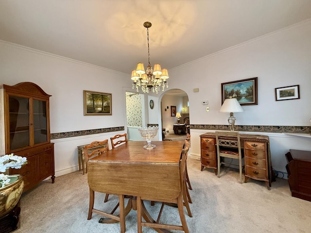 dining area featuring light carpet, a notable chandelier, crown molding, and arched walkways