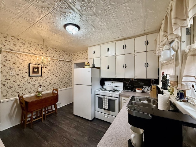 kitchen with white cabinetry, an ornate ceiling, dark wood-type flooring, white appliances, and wainscoting