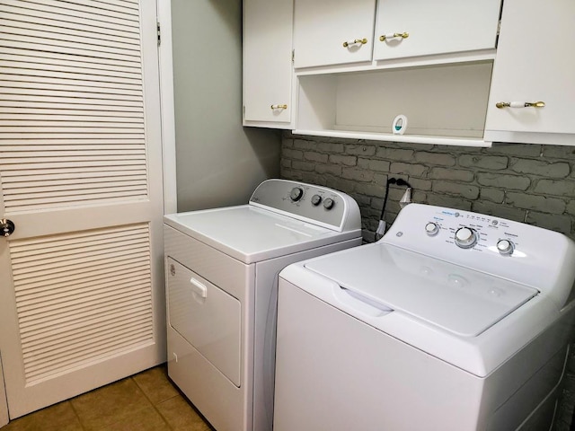 laundry room featuring tile patterned floors, cabinet space, and washer and clothes dryer