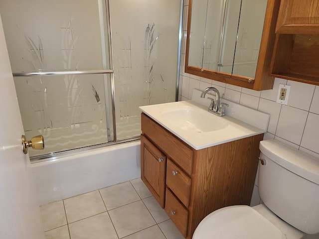 bathroom with backsplash, vanity, tile patterned floors, bath / shower combo with glass door, and toilet