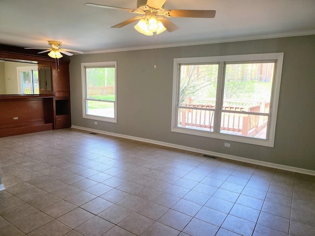 tiled spare room featuring crown molding, a ceiling fan, baseboards, and visible vents