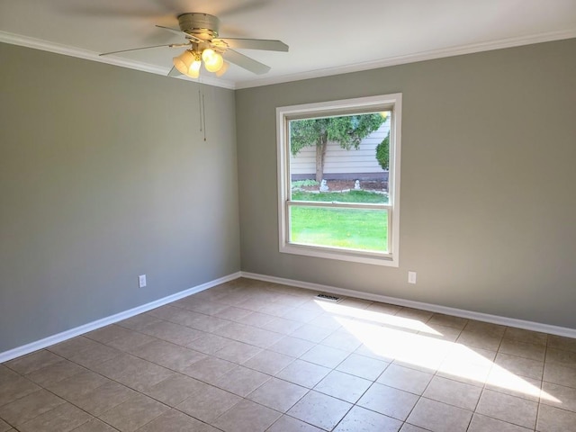 empty room featuring tile patterned flooring, ornamental molding, baseboards, and a ceiling fan