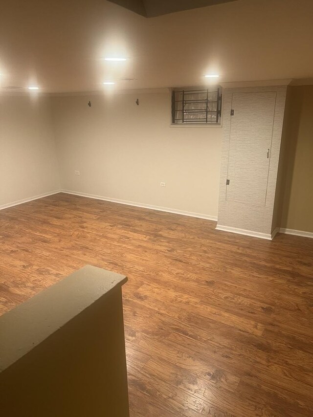 spare room featuring baseboards and wood finished floors