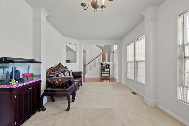 living area with stairway, a wealth of natural light, and light colored carpet
