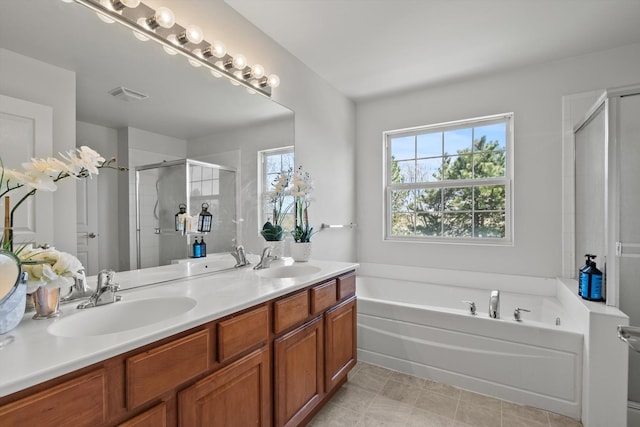 bathroom with a garden tub, a stall shower, a sink, and visible vents