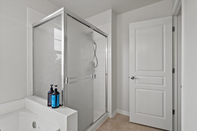 full bathroom with tile patterned floors, baseboards, a shower stall, and a bath