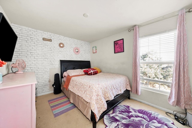 bedroom with a fireplace, brick wall, light carpet, and baseboards