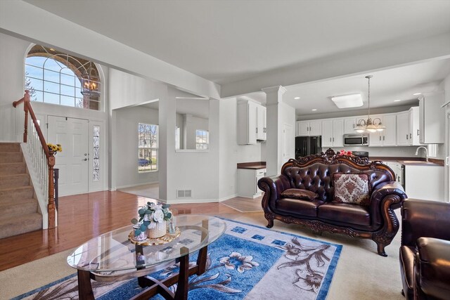 living room with visible vents, plenty of natural light, baseboards, and stairs