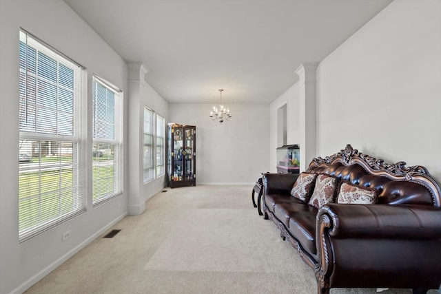 living area with baseboards, visible vents, light carpet, and a notable chandelier