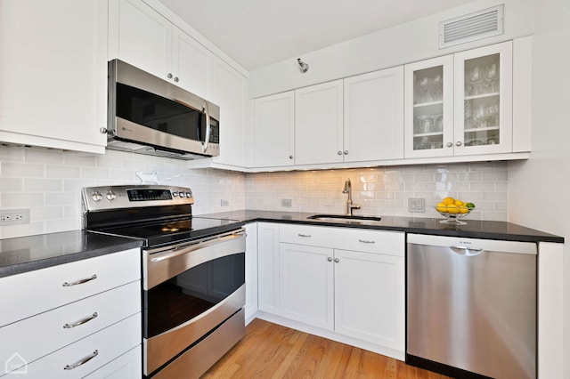 kitchen featuring a sink, stainless steel appliances, white cabinetry, and visible vents