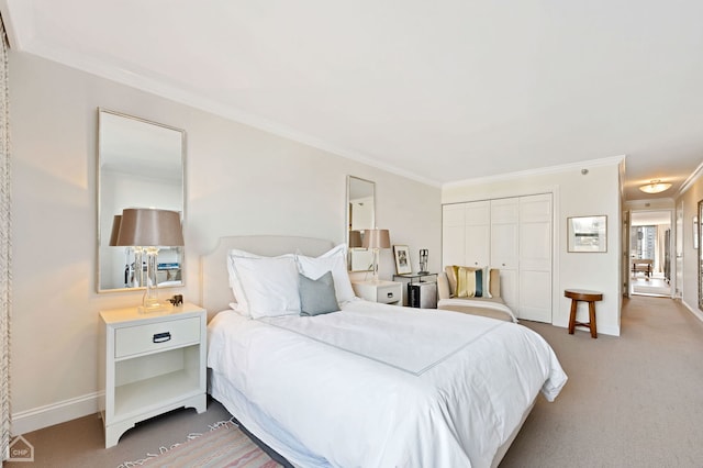 bedroom featuring a closet, baseboards, ornamental molding, and carpet flooring