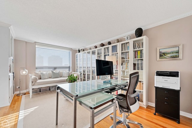 office featuring light wood-style floors, ornamental molding, a textured ceiling, and baseboards