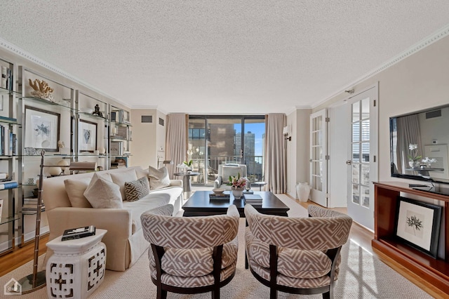 living area with crown molding, a textured ceiling, french doors, and wood finished floors