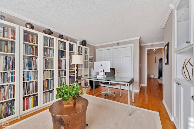 office area featuring baseboards, a textured ceiling, ornamental molding, and wood finished floors
