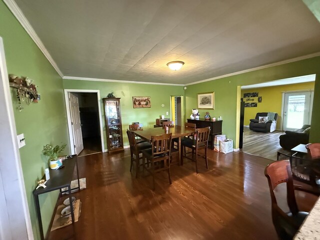 kitchen with a kitchen breakfast bar, crown molding, a sink, baseboards, and stainless steel appliances