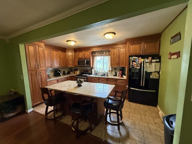 kitchen with appliances with stainless steel finishes, backsplash, brown cabinets, and light stone countertops