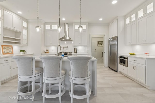 13 Briden Ln Unit 13, Sycamore, IL 60178 - kitchen with appliances with stainless steel finishes, wall chimney range hood, a kitchen island with sink, light countertops, and a sink