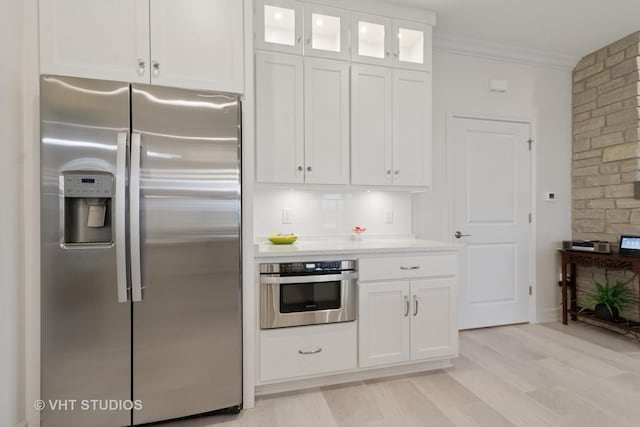 13 Briden Ln Unit 13, Sycamore, IL 60178 - kitchen with stainless steel appliances, white cabinets, light countertops, crown molding, and glass insert cabinets