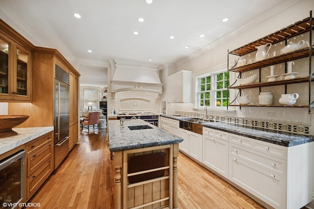 475 Maple St, Winnetka, IL 60093 - kitchen featuring custom exhaust hood, beverage cooler, open shelves, ornamental molding, and light wood-style floors