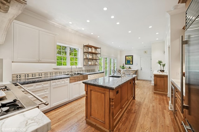475 Maple St, Winnetka, IL 60093 - kitchen with light wood-style floors, light stone counters, recessed lighting, an island with sink, and white cabinetry