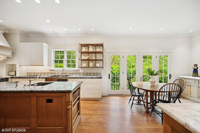475 Maple St, Winnetka, IL 60093 - kitchen featuring crown molding, backsplash, light stone countertops, light wood-type flooring, and white cabinetry