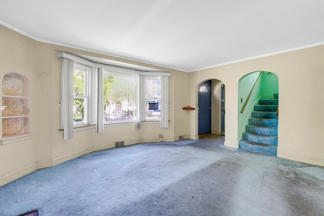 3134 N Mason Ave, Chicago, IL 60634 - unfurnished living room featuring carpet floors, crown molding, baseboards, stairs, and arched walkways