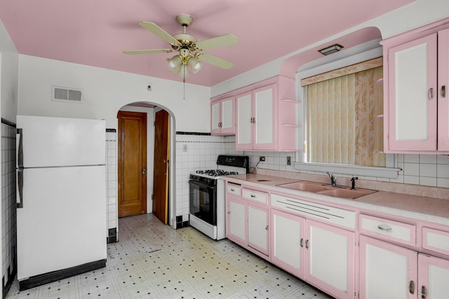 3134 N Mason Ave, Chicago, IL 60634 - kitchen featuring range with gas cooktop, freestanding refrigerator, a sink, arched walkways, and ceiling fan