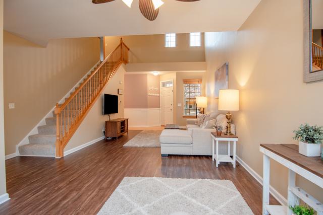 738 Dillon Ct, Grayslake, IL 60030 - living area featuring stairway, wood finished floors, ceiling fan, and baseboards