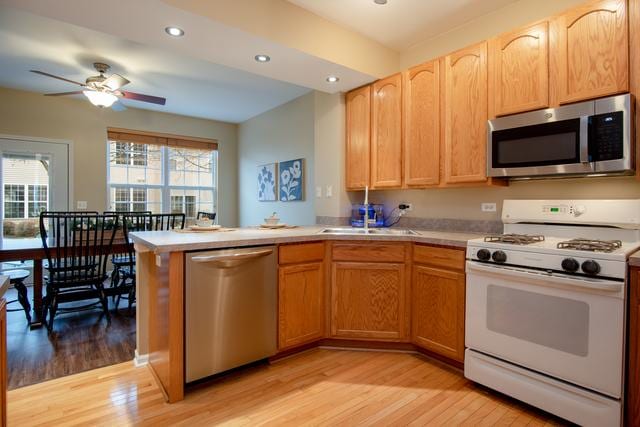 738 Dillon Ct, Grayslake, IL 60030 - kitchen featuring stainless steel appliances, light wood finished floors, a peninsula, light countertops, and recessed lighting