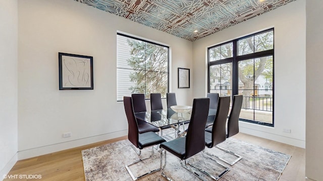 dining room with an ornate ceiling, wood finished floors, and baseboards