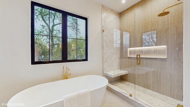full bath with a freestanding tub and a stall shower