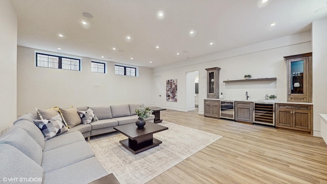 living room featuring wine cooler, light wood finished floors, and wet bar