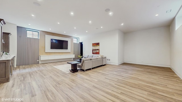 living area with recessed lighting, visible vents, light wood-style flooring, and baseboards