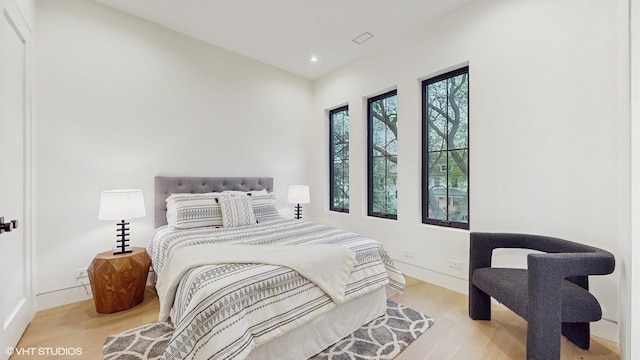 bedroom featuring wood finished floors, recessed lighting, and baseboards