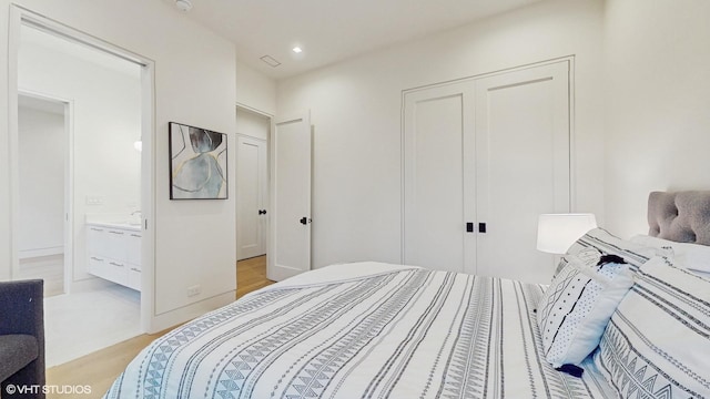 bedroom featuring light wood-type flooring, connected bathroom, a closet, and recessed lighting