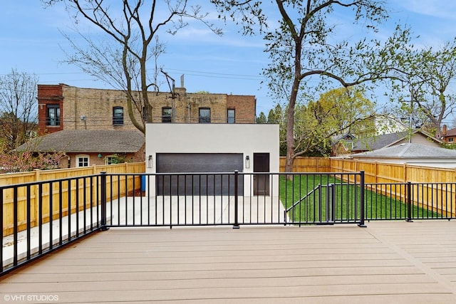 wooden deck featuring a garage, a yard, and a fenced backyard