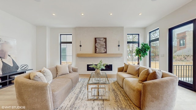 living area with a fireplace, wood finished floors, and recessed lighting
