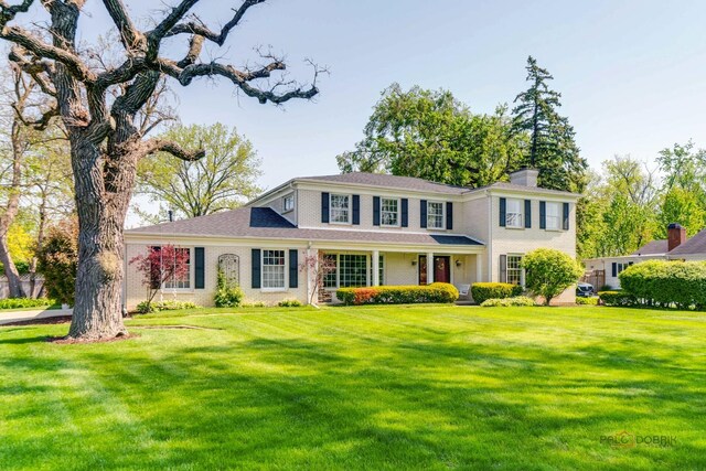 1878 Hackberry Ln, Lake Forest, IL 60045 - colonial home with a front lawn, a chimney, and brick siding