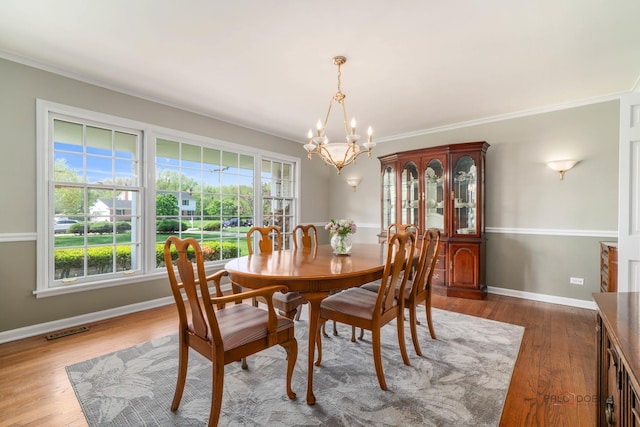 1878 Hackberry Ln, Lake Forest, IL 60045 - dining area featuring a chandelier, baseboards, wood finished floors, and crown molding