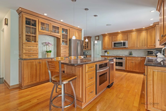 1878 Hackberry Ln, Lake Forest, IL 60045 - kitchen featuring appliances with stainless steel finishes, light wood-type flooring, brown cabinetry, a center island, and recessed lighting