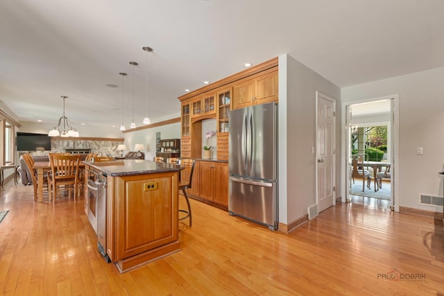 1878 Hackberry Ln, Lake Forest, IL 60045 - kitchen featuring freestanding refrigerator, brown cabinetry, light wood finished floors, a kitchen island, and recessed lighting