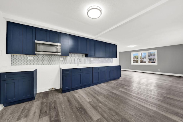 1401 Stanley Blvd, Calumet City, IL 60409 - kitchen featuring a sink, stainless steel microwave, dark wood-type flooring, backsplash, and blue cabinets