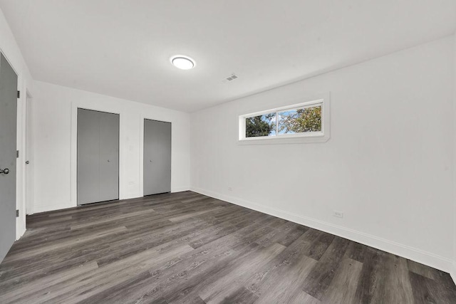 1401 Stanley Blvd, Calumet City, IL 60409 - unfurnished bedroom with two closets, baseboards, visible vents, and wood finished floors