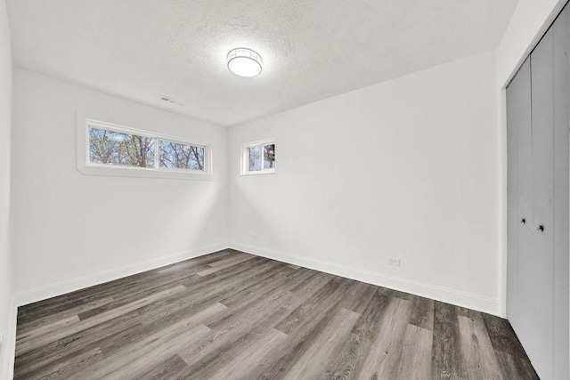 1401 Stanley Blvd, Calumet City, IL 60409 - unfurnished bedroom with a textured ceiling, baseboards, a closet, and wood finished floors